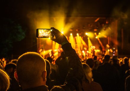 People in front of an illuminated concert stage 