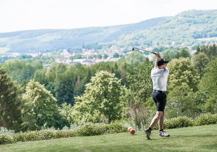 Man plays golf with a view of green nature