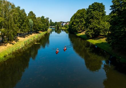 Two people paddling in a red canoe on the River Werre